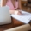 Woman filling in registration forms next to a laptop