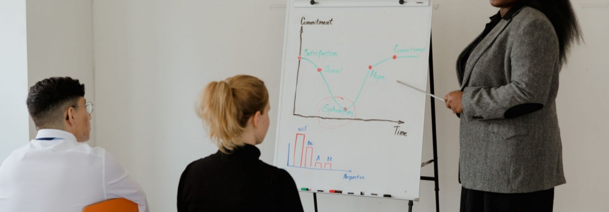Manager explaining a chart to her team while delegating work in a small business