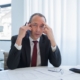 Stressed business owner on the phone at his desk, a sign of founder dependency