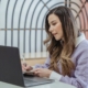 Entrepreneur writing notes at a laptop while working on a business plan