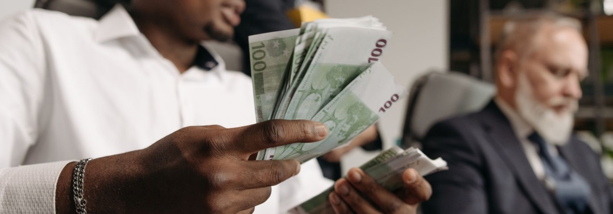 Business owner counting cash in a meeting about small business funding